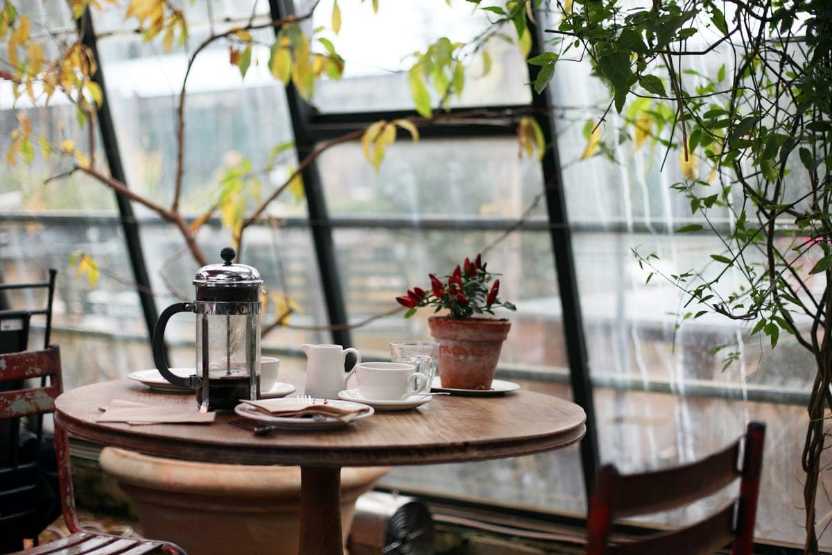 Kaffeetisch mit zwei Tassen und Stempelkanne am Fenster